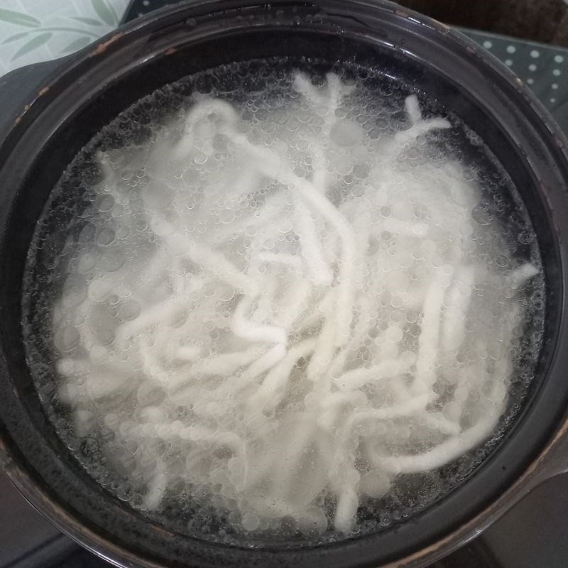Sợi bánh bột lọc đang được luộc trong nước dùng, đảm bảo độ trong và dai hoàn hảo