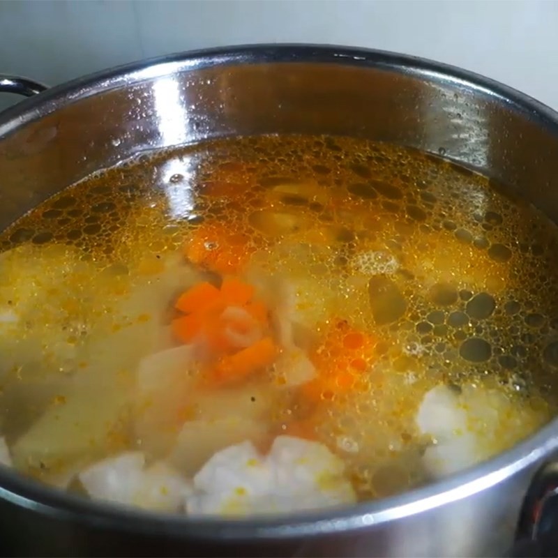 Nồi bún cá cam đang sôi nhẹ, các nguyên liệu hòa quyện tạo nên hương vị hấp dẫn