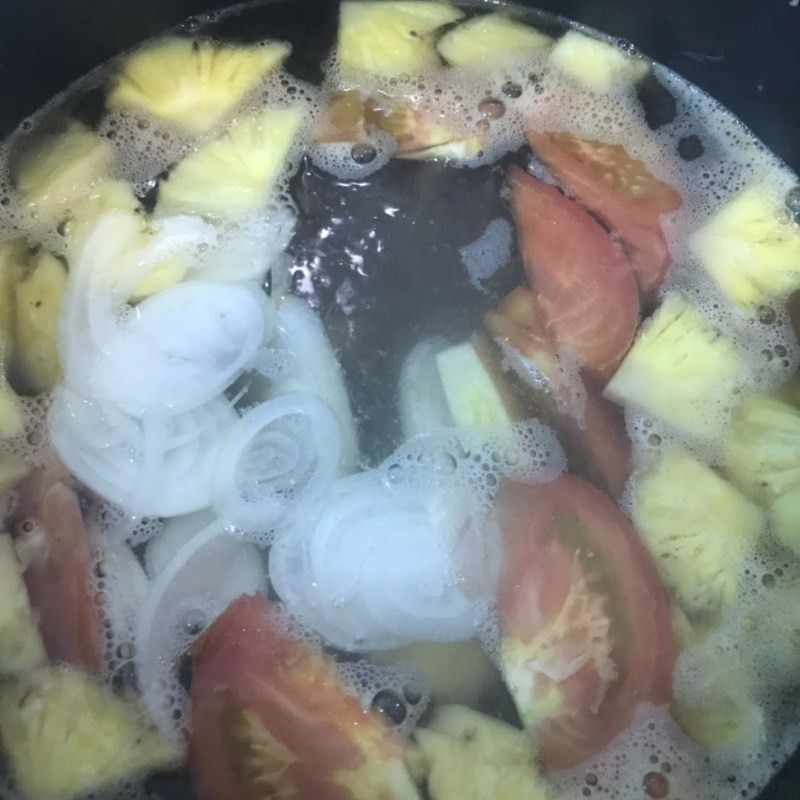 Nêm gia vị và cho cá ngừ vào nấu trong nồi nước dùng bún cá sứa