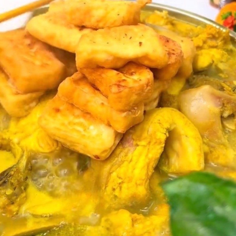 Nồi cá ngạnh om chuối đậu đang sôi liu riu, tỏa hương thơm nồng nàn của mẻ và nghệ.