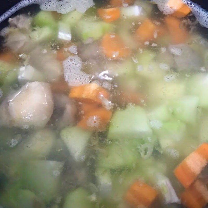 Nồi canh xương hầm rau củ đang sôi, tỏa hương thơm