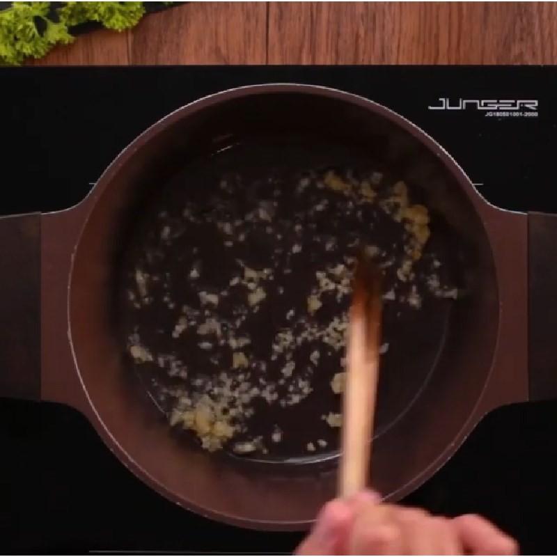 Xào tỏi thơm và măng chua trước khi nấu canh chua cá hú