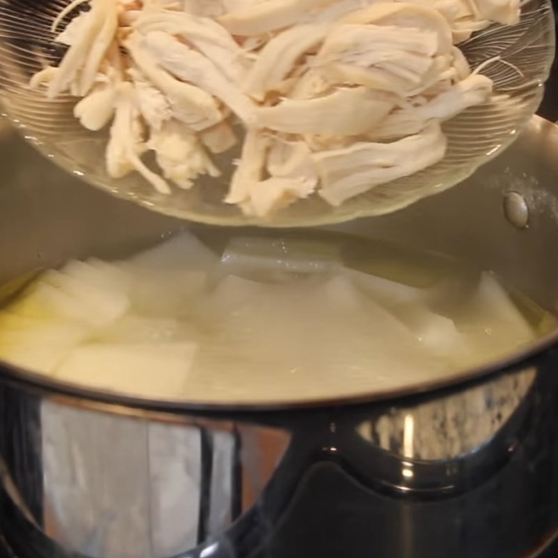 Thêm thịt gà xé vào nồi canh củ cải để tăng hương vị