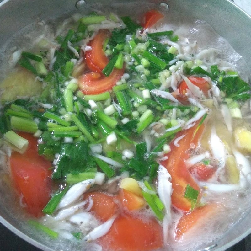 Đổ nước và cho củ cải vào chảo cá hồi để nấu canh củ cải