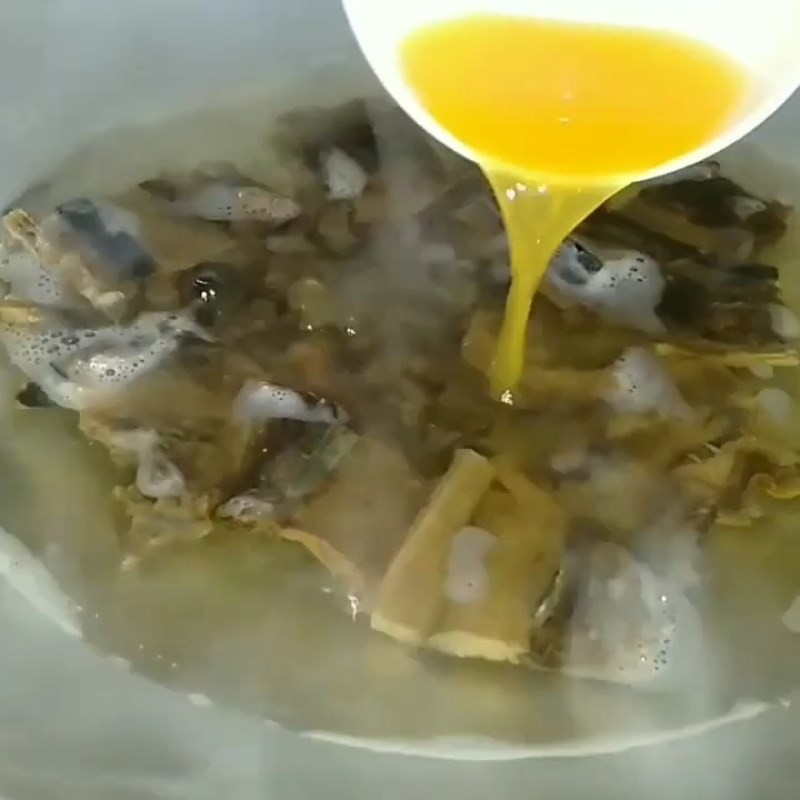 Rắc hành lá cắt nhỏ vào nồi canh mực nhồi thịt đã hoàn thành