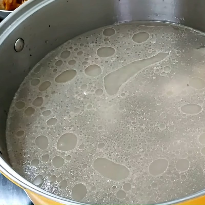 Thêm măng chua vào nồi canh đang sôi, bước quan trọng trong cách nấu canh măng chua