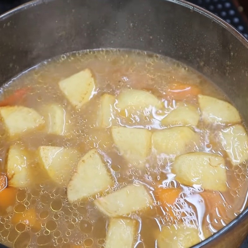 Nồi canh thịt bò khoai tây cà rốt đang sôi, chuẩn bị hoàn thành