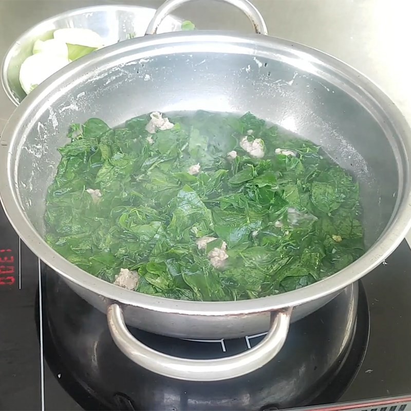 Thêm nấm kim châm vào nồi canh khi gần chín, hoàn thiện món canh kim chi thịt heo theo cách nấu canh kim chi đơn giản.