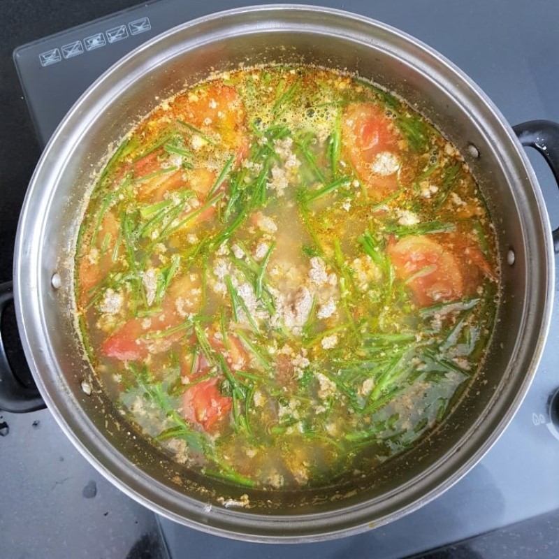 Nêm nếm gia vị, cho mẻ và thì là vào nồi, hoàn thiện món canh cua chua đậm đà hương vị truyền thống.