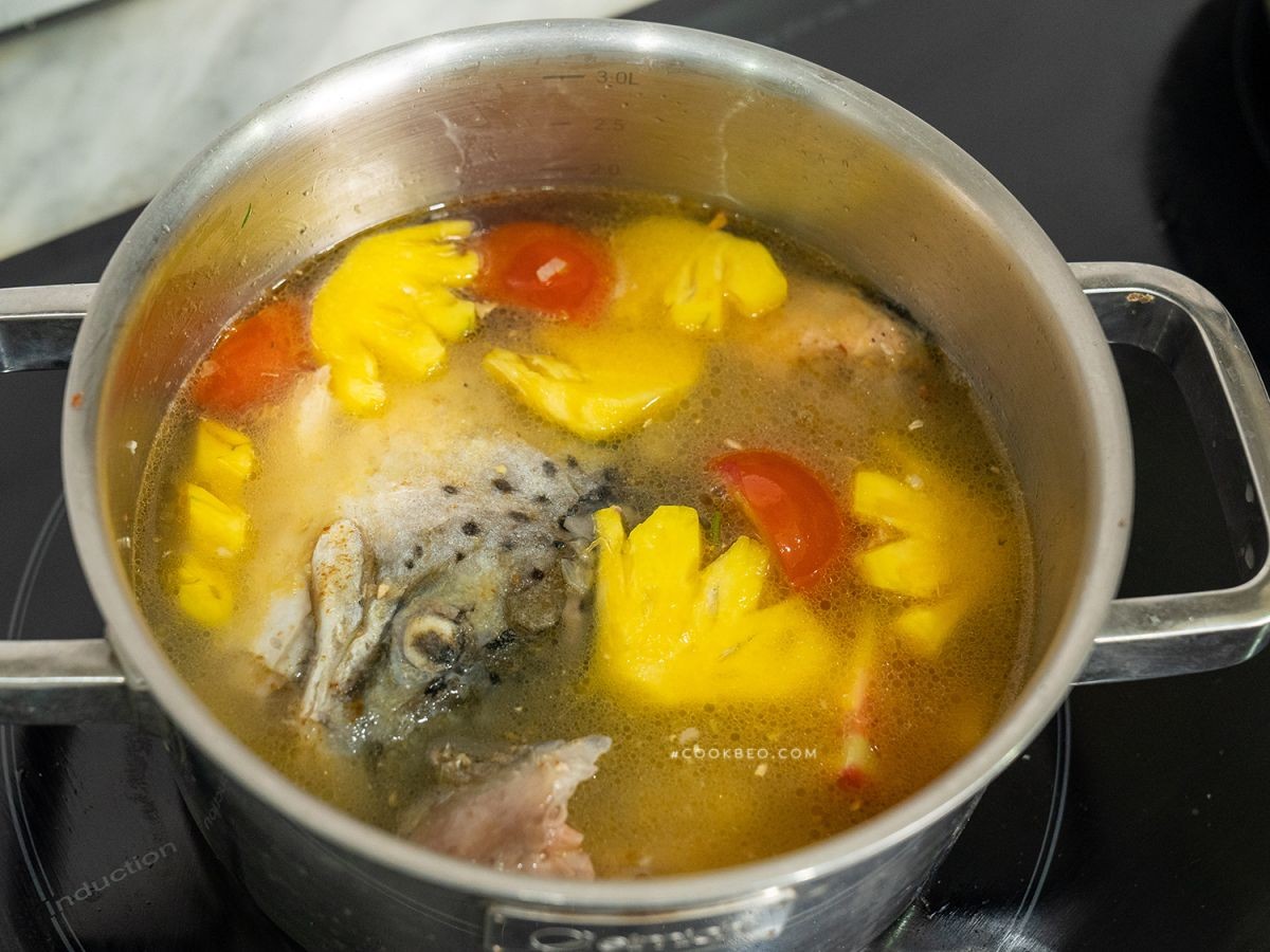 Nồi canh cá hồi với dứa đang sôi trên bếp