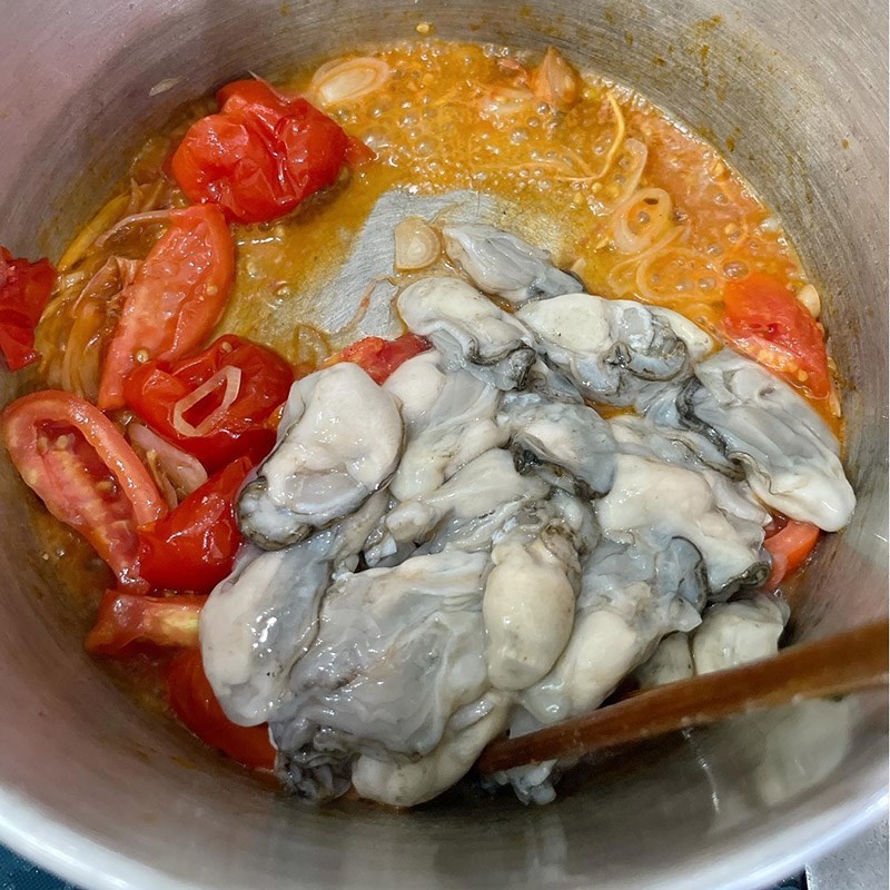 Hàu sữa tươi đang được xào sơ cùng cà chua và hành gừng trong nồi
