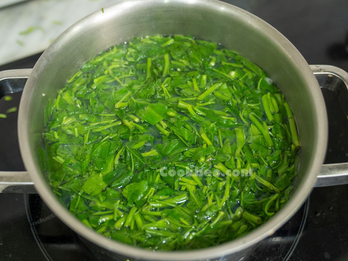 Nồi canh ngao rau muống đang sôi trên bếp, rau muống xanh mướt, chuẩn bị hoàn thành món ăn thanh mát.