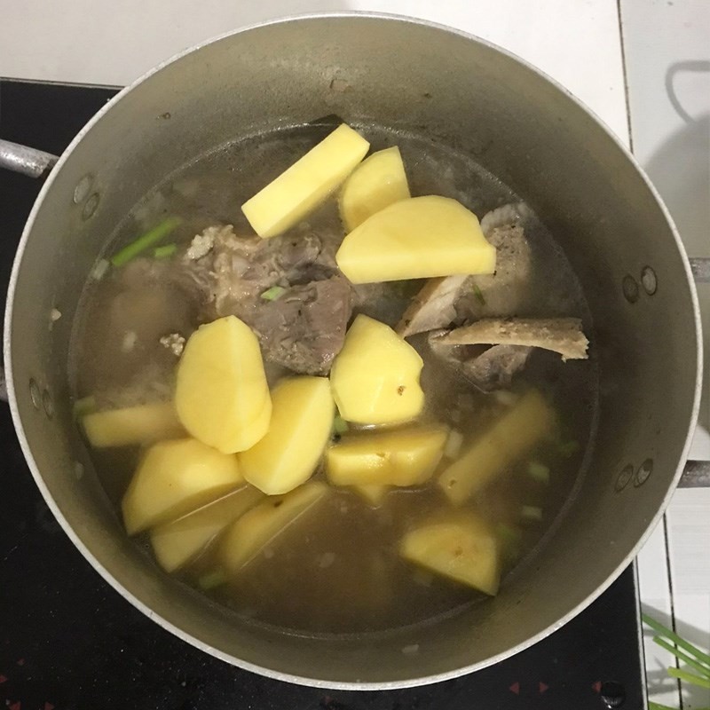 Hầm xương bò và vớt bọt để nước canh trong, sau đó sẽ thêm khoai tây đã bổ theo cách nấu canh