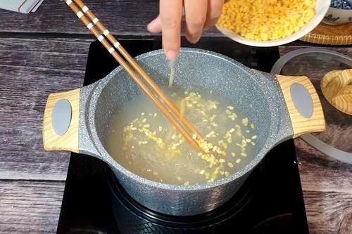 Cho đậu xanh vào nồi chè bột năng để hoàn thành món chè đậu xanh