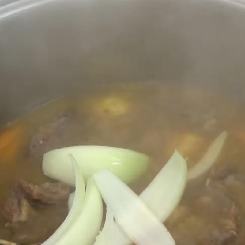Hoàn thiện món lagu lưỡi bò bằng cách thêm hành tây và sốt cà chua, sau đó nêm nếm