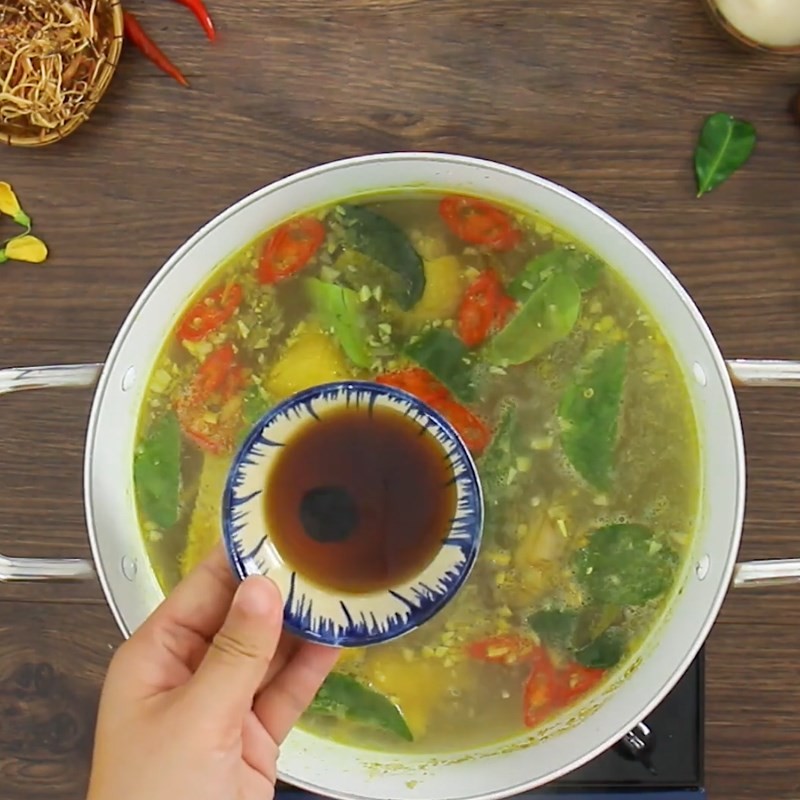 Đảo nhẹ canh chua để các nguyên liệu hòa quyện