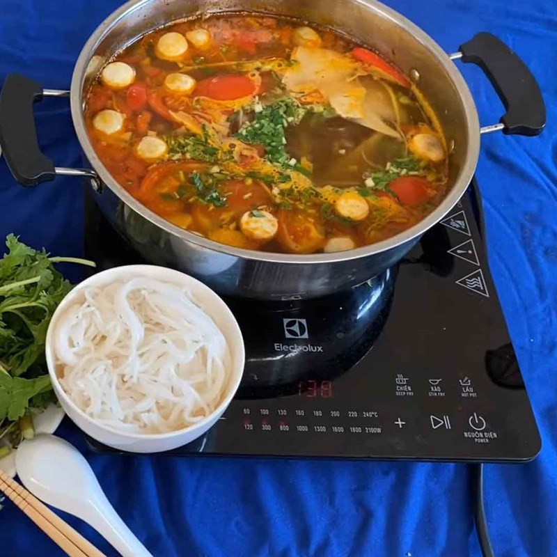 Hoàn thiện nước lẩu cá mú măng chua với hành ngò tươi