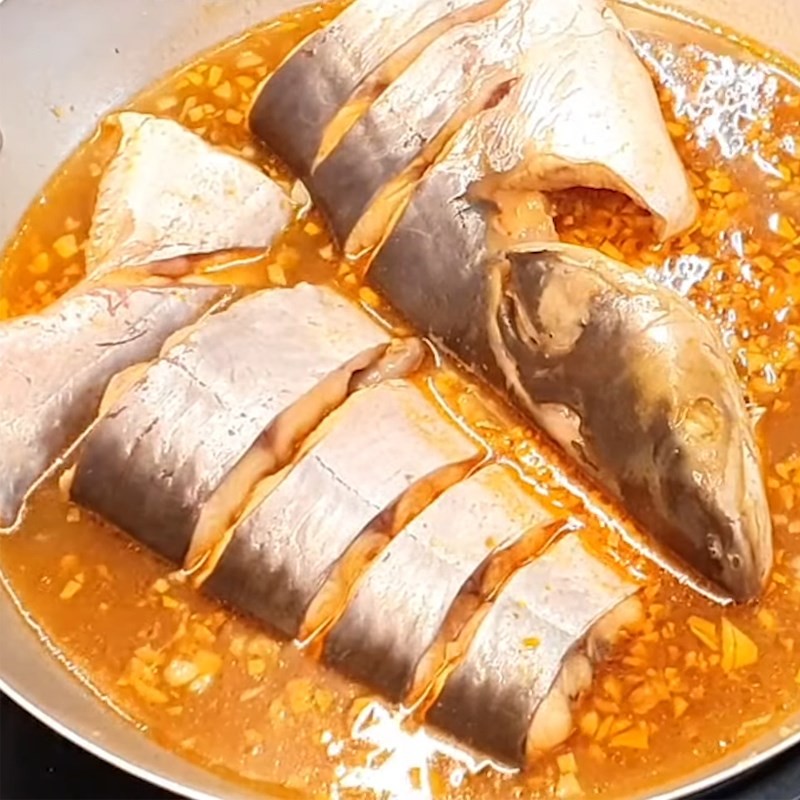 Thêm cá tra đã ướp vào nồi lẩu đang sôi