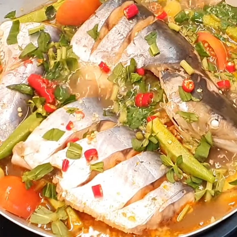 Nồi lẩu cá tra chua cay đầy đủ rau củ và cá đang sôi