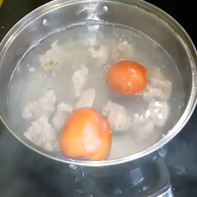 Ninh sườn và cà chua để lấy nước dùng cho lẩu lòng heo
