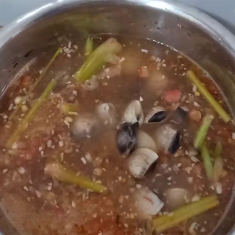 Nghêu tươi được cho vào nồi nước lẩu đang sôi sùng sục, chuẩn bị chín tới và há miệng, tạo nên món lẩu nghêu chua cay hấp dẫn