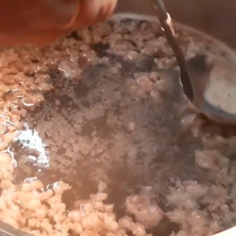 Thêm thịt bằm vào nồi nước sôi để làm nước dùng canh khổ qua