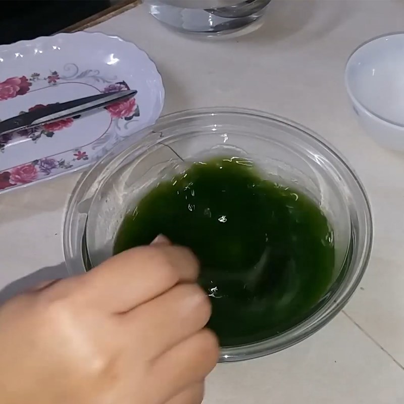 Bước 2 trong cách nấu chè cốm Hà Nội: Nấu nước dứa đã pha đường và bột năng trên bếp, khuấy đều để tạo độ sánh mịn cho chè.