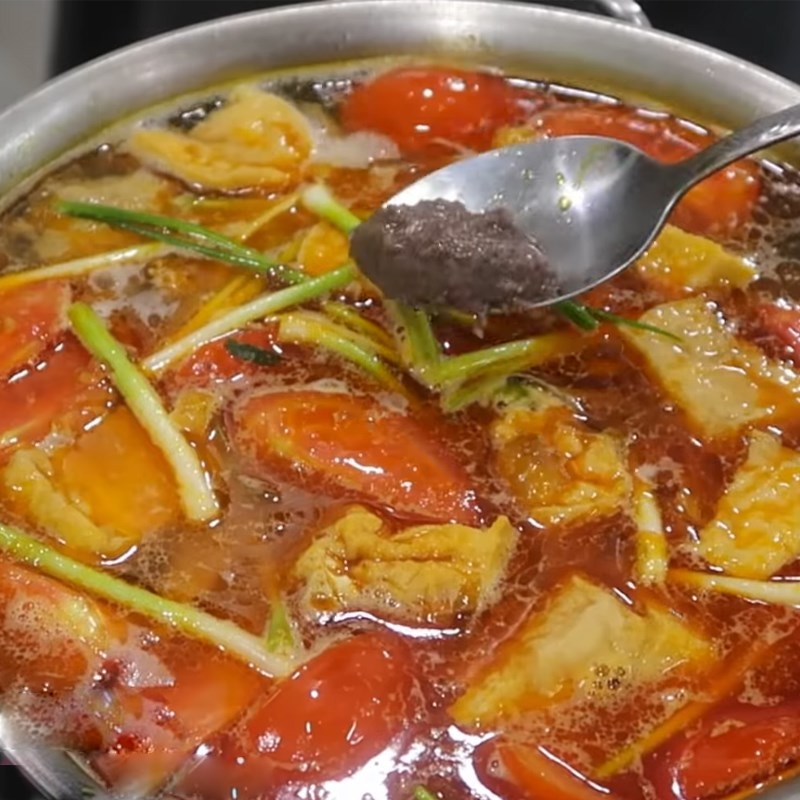 Nêm nếm gia vị vào nồi nước dùng bún chả cá chay đang sôi
