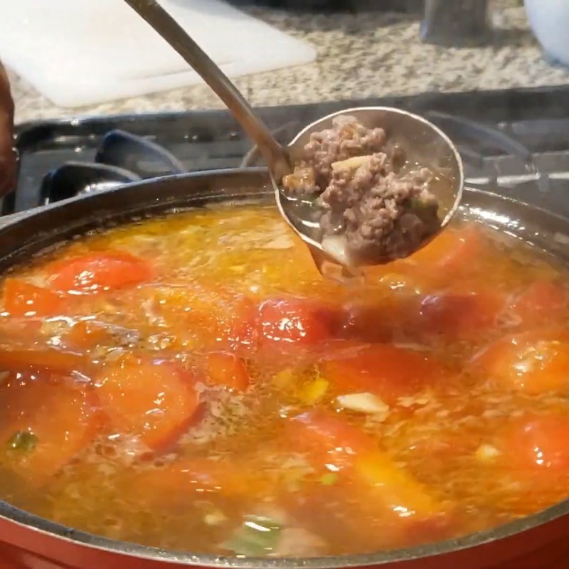 Nước dùng bún bò cà chua đang sôi trong nồi lớn