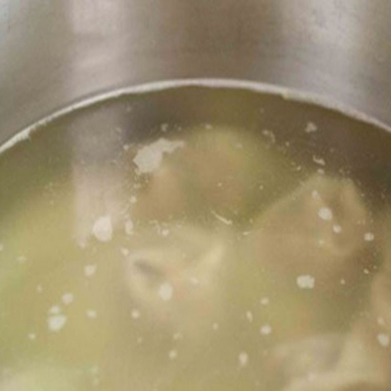 Nồi nước dùng xương cá và hành tím đang sôi nhẹ, tạo vị ngọt thanh cho bánh canh chả cá Quy Nhơn