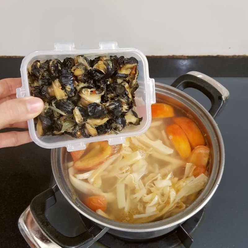 Nêm nếm gia vị cho nước dùng bún ốc măng, điều chỉnh độ mặn ngọt chua cay vừa khẩu vị gia đình.