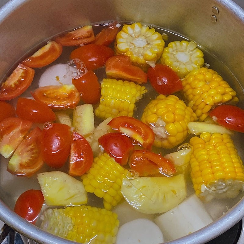 Nước dùng bún mọc chay đang được ninh cùng cà chua, ngô và củ cải