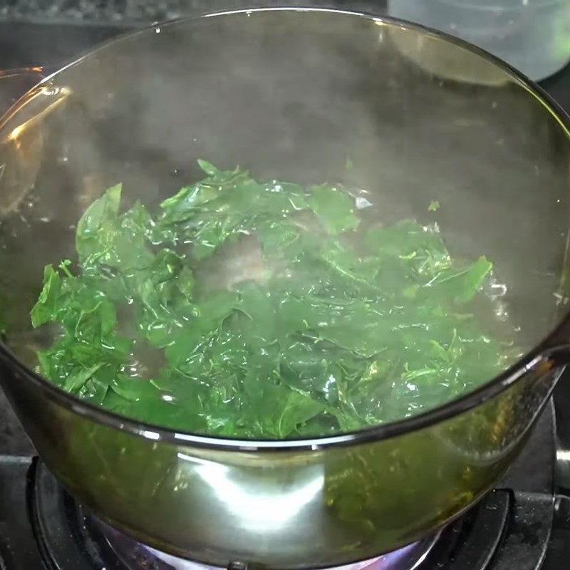 Cho thịt gà ác vào nồi rau ngót đang nấu