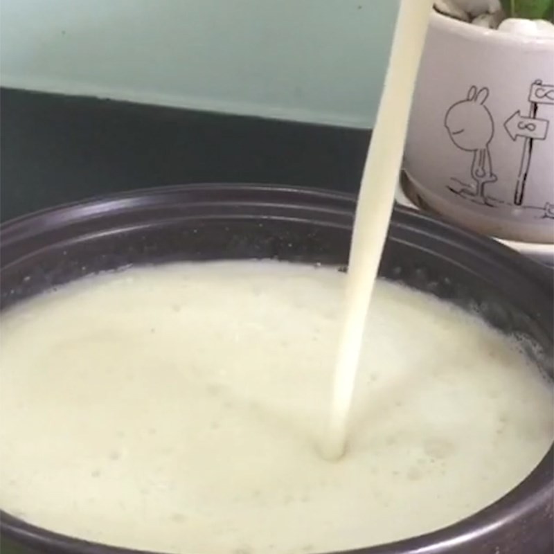 Nấu sữa hạt sen khoai môn trên bếp với lửa nhỏ và khuấy đều cho bé ăn dặm