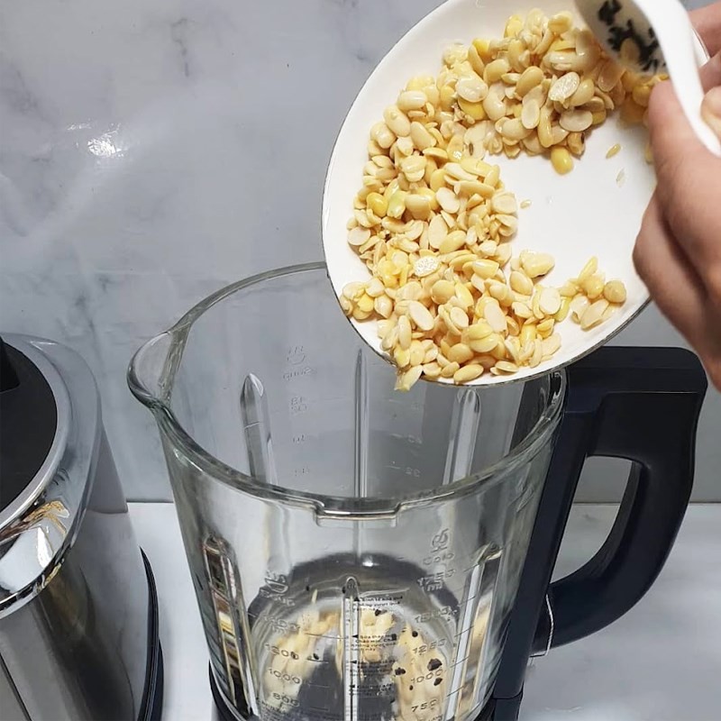 Cho đậu nành và mè đen đã sơ chế vào máy làm sữa hạt để nấu