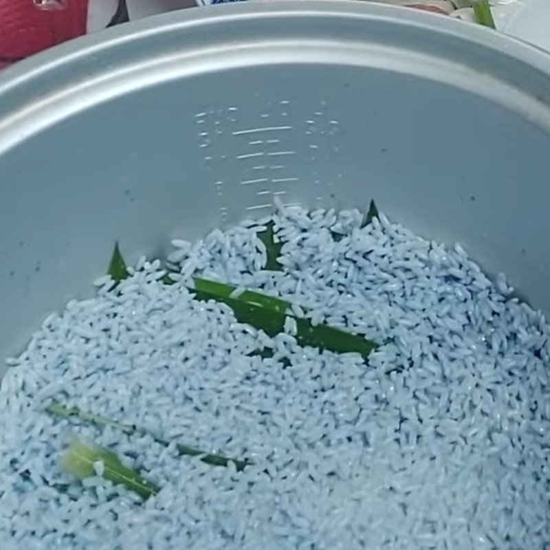 Cho gạo nếp đã ngâm và lá dứa vào nồi cơm điện để nấu xôi