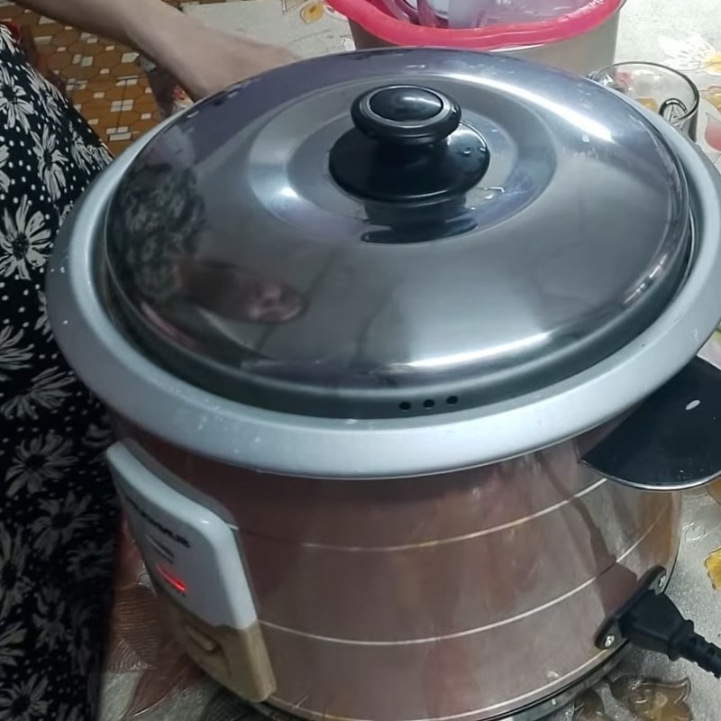 Nồi cơm điện đang làm chín xôi hoa đậu biếc lá dứa