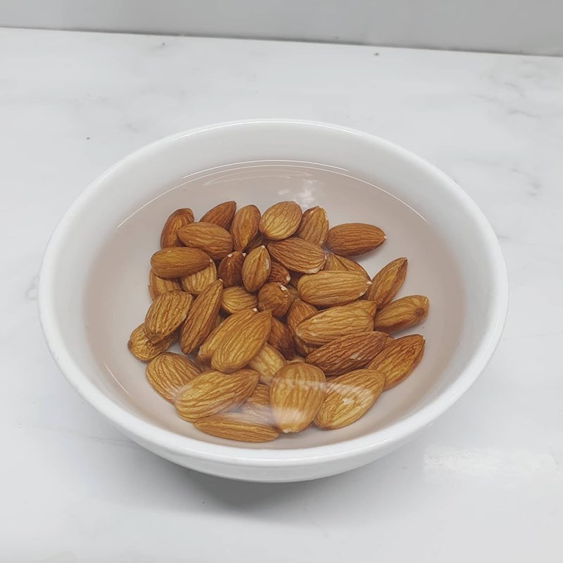 Hình ảnh hạnh nhân đang được ngâm trong nước để làm mềm và loại bỏ vỏ lụa