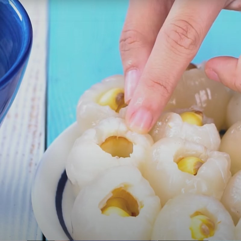 Nhồi từng hạt sen vào quả vải đã tách hạt một cách khéo léo