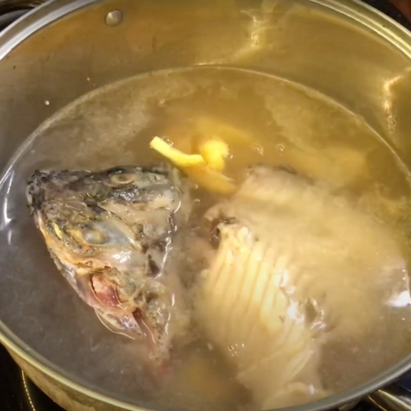 Vớt bọt trong quá trình ninh nước dùng bún cá rô phi để nước trong và ngon hơn