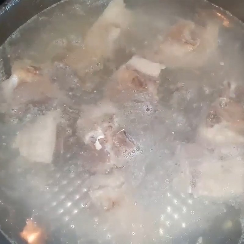 Ninh xương heo trên bếp, vớt bọt để nước dùng trong