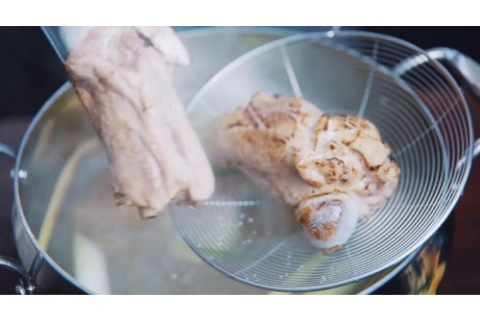 Nồi nước dùng xương ống đang được ninh trên bếp, tạo vị ngọt tự nhiên cho lẩu cá chép giòn nhúng mẻ