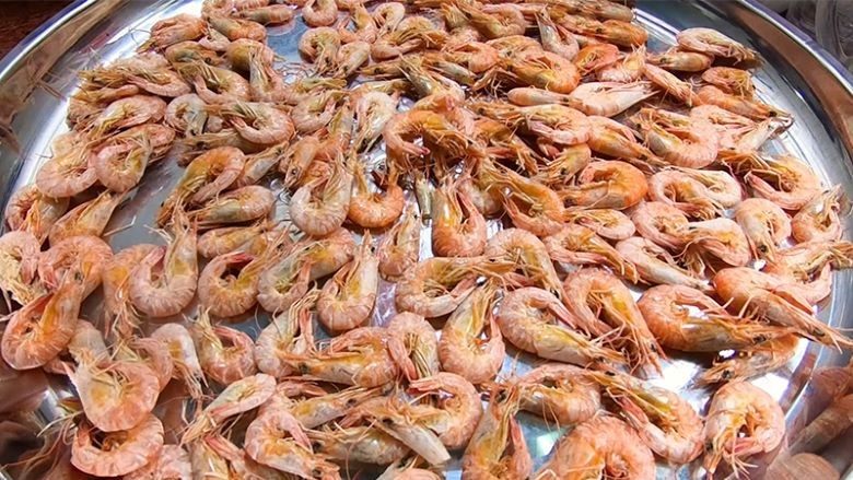 Tôm đã luộc được phơi dưới nắng, một bước quan trọng trong cách làm tôm khô mềm