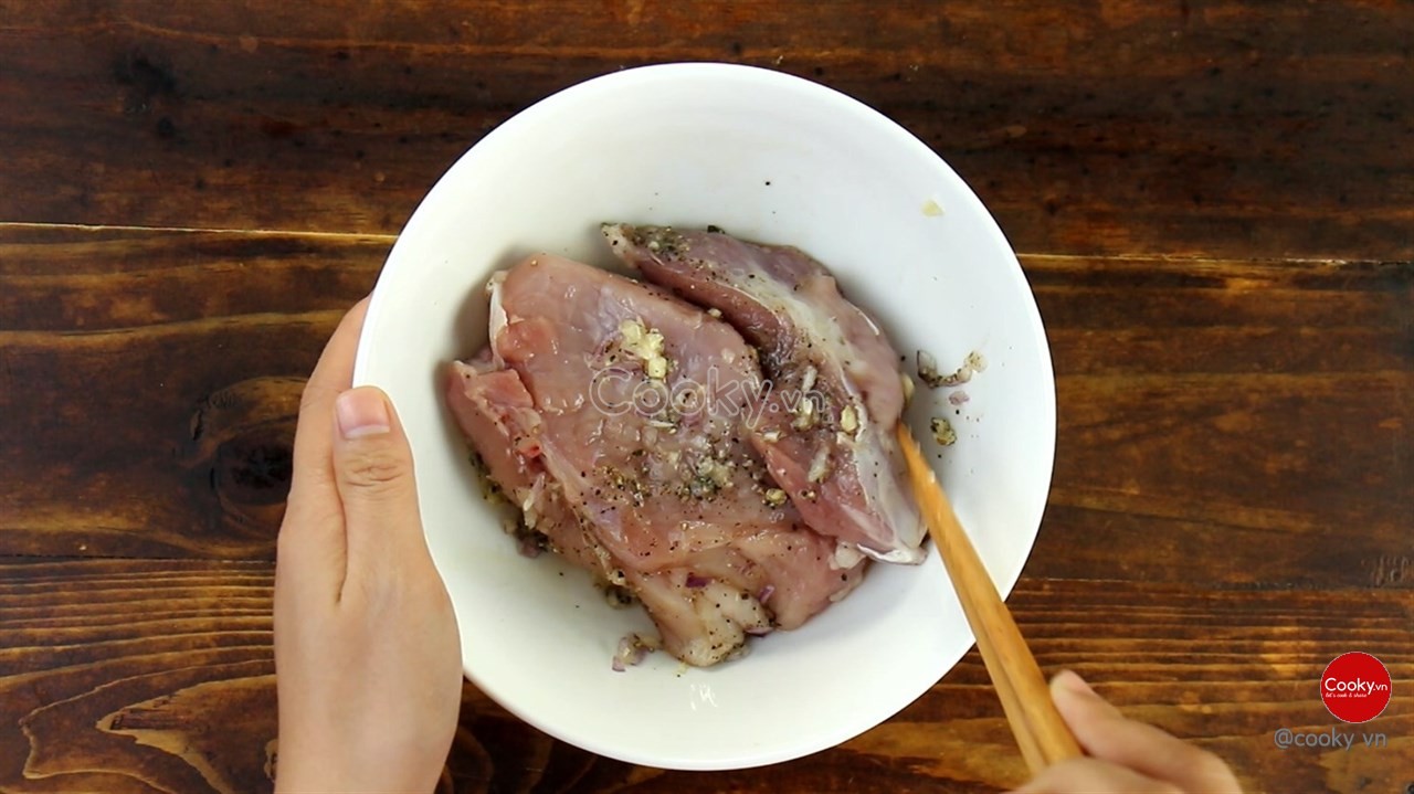 Sườn cốt lết đã thái lát đang được ướp với gia vị đậm đà cho món cơm tấm Sài Gòn