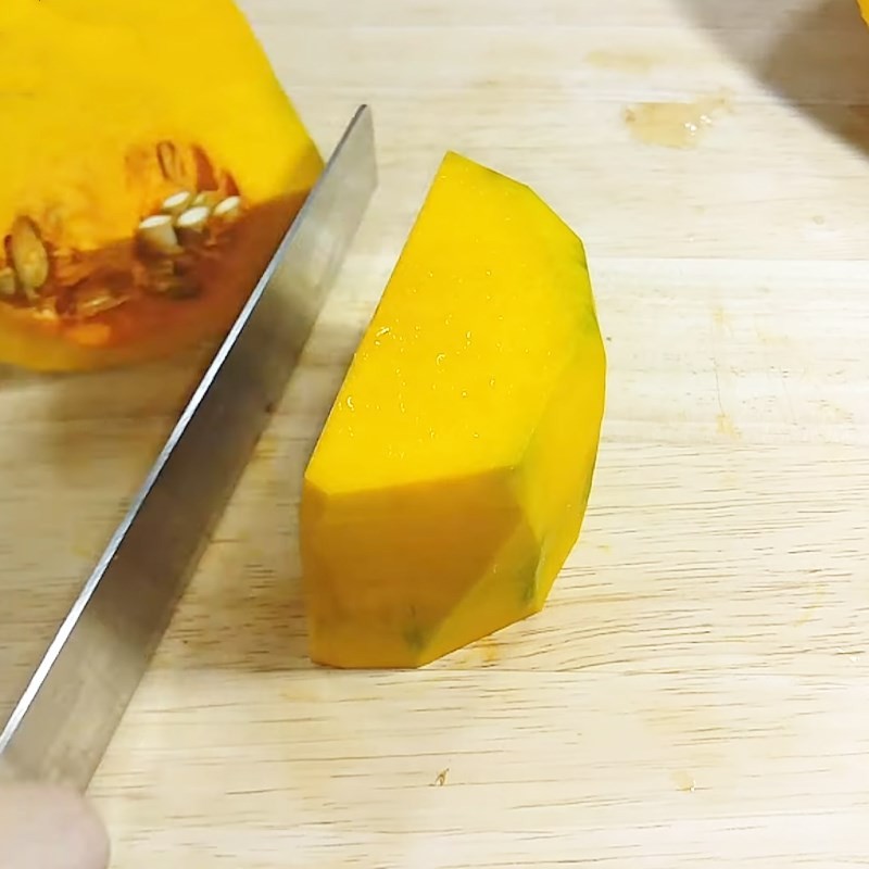 Loại bỏ ruột bí đỏ để chuẩn bị cho cách nấu cà ri bí đỏ chay thanh ngọt