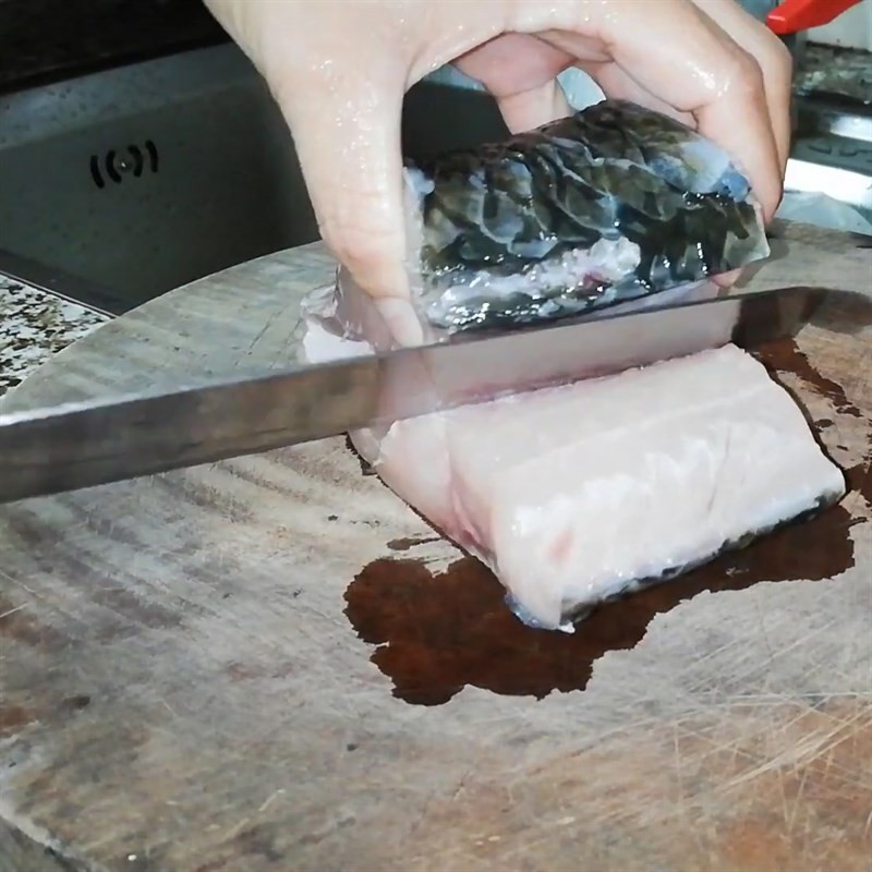 Cắt khúc cá trắm sau khi sơ chế sạch để nấu canh dưa chua