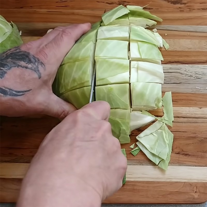 Cắt bắp cải thành miếng lớn, chuẩn bị cho món canh bắp cải cà chua dùng cà chua hộp