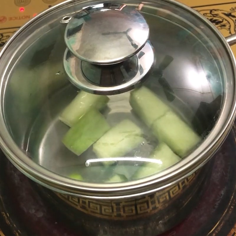 Gọt vỏ và cắt bí xanh để chuẩn bị nấu cháo đậu đỏ cho bé ăn dặm
