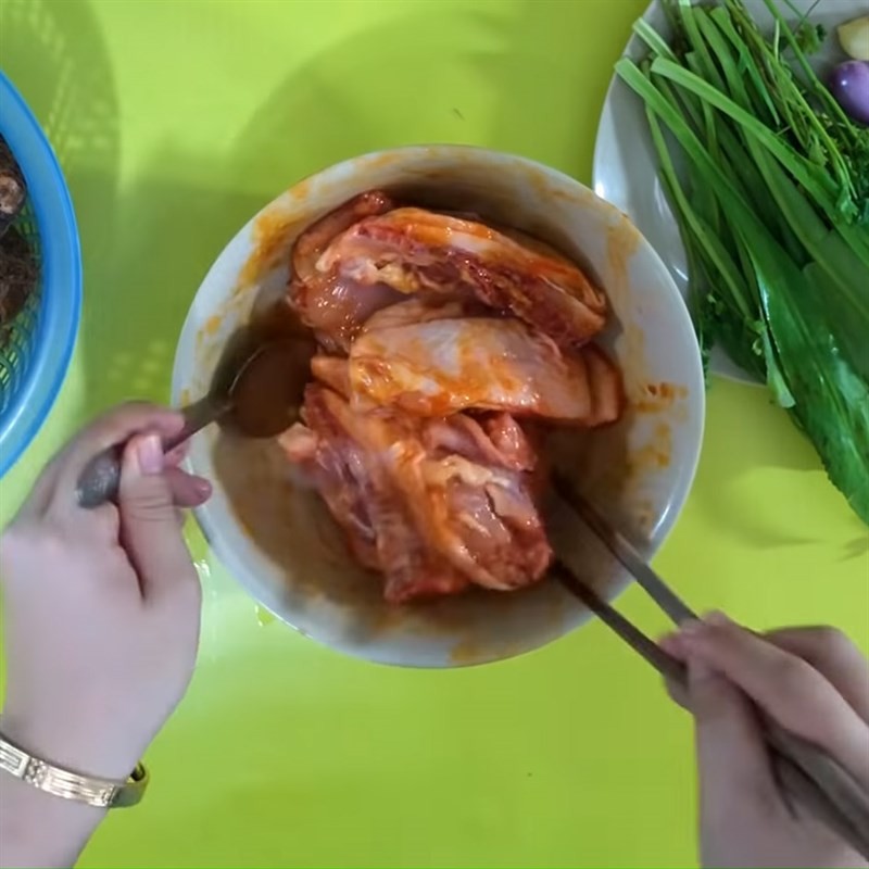 Ướp thịt gà với gia vị trong tô lớn, bước quan trọng khi nấu canh xương gà