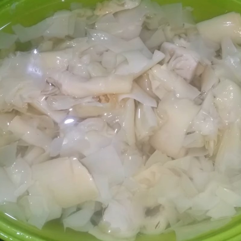 Măng chua được rửa sạch dưới vòi nước, loại bỏ tạp chất trước khi luộc